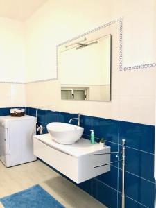 W łazience znajduje się biała umywalka i lustro. w obiekcie Relax Maratea w mieście Maratea