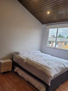 Un dormitorio con una cama grande y una ventana en HOMY APARTAMENTOS #8 - Apt Grande G12 Agora Corferias embassy UN, en Bogotá