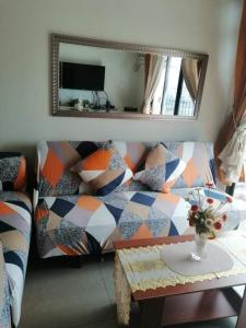 ein Wohnzimmer mit einem Sofa und einem Spiegel in der Unterkunft 2BR Portovita Condominium North Tower in Manila