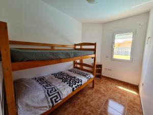 a bedroom with two bunk beds in a room at Beach Villas 16 con piscina privada in Caleta De Fuste +32 photos