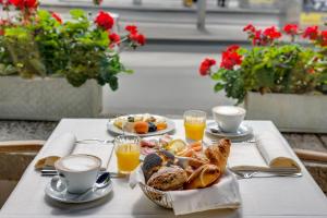 a table with a breakfast of bread and orange juice at Hotel Euler Basel in Basel