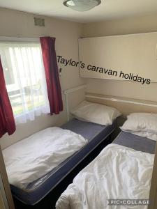 インゴールドメルズにあるTaylor's Caravan Holiday's 9 berthのツインベッド2台 窓付きの部屋