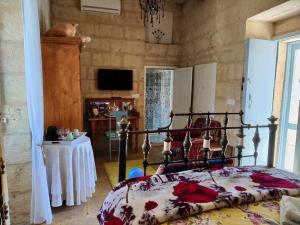 a bedroom with a bed and a table and a television at The Garden Gate in Sannat