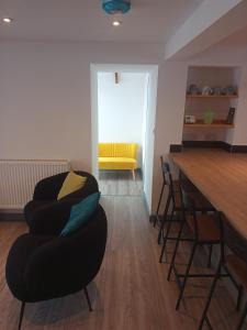 a living room with a table and chairs and a yellow bench at Sam's retreat in Hayle