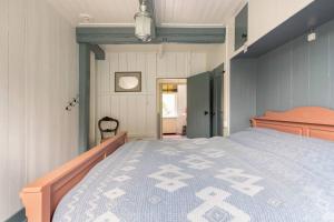 a bedroom with a bed with a blue and white comforter at Private Characteristic farmhouse near the lake in Andijk