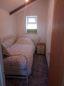 a small bedroom with a bed and a window at Sam's retreat in Hayle