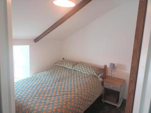 a bedroom with a bed with a blue comforter at Sam's retreat in Hayle