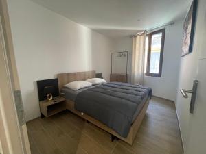 sypialnia z dużym łóżkiem i oknem w obiekcie Ibanova Appartements w mieście Collioure