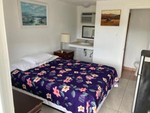 1 dormitorio con 1 cama con manta morada en Riviera Motor Lodge, en Myrtle Beach