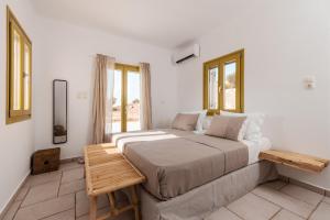 1 dormitorio con 1 cama grande y 2 ventanas en Ventu Paros Villa en Márpissa