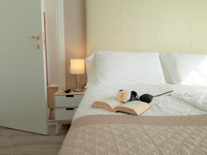 Una cama con un libro y una muñeca encima. en Hotel Danubio, en Lido di Jesolo