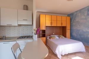 eine Küche mit einem Bett und einem Tisch mit Blumen in der Unterkunft Agriturismo Gli Etruschi in Populonia
