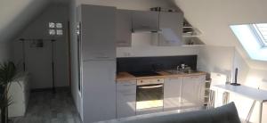 una cocina blanca con armarios blancos y fregadero en Appartement cosy + accès jardin et salle de muscu, en Mardié