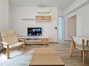 a living room with a tv and a table and chairs at Puerto benidorm center in Benidorm