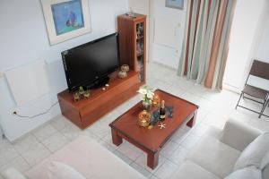 a living room with a flat screen tv and a coffee table at Stardust, the studio in Adamas