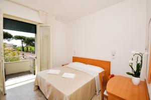 a bedroom with a bed and a large window at Hotel Airone in Marina di Pietrasanta