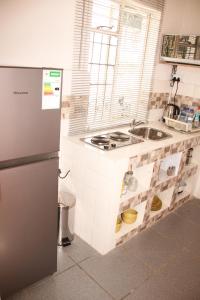 eine Küche mit einer Spüle und einem Kühlschrank in der Unterkunft Lovely 1-bedroom flat in Germiston in Germiston
