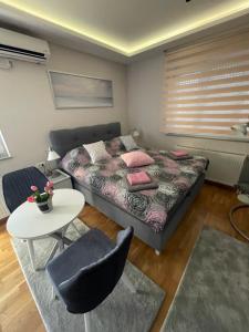 a bedroom with a bed and a table and chairs at Apartman Spa Bačka in Bačka Palanka