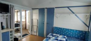 een blauwe en witte kamer met een bank en een raam bij Camping Le Logis 3 étoiles in Saint-Jean-de-Monts