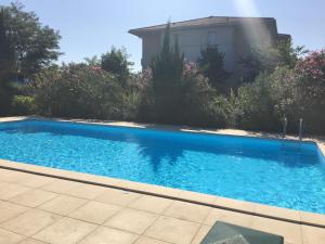 uma piscina azul em frente a uma casa em Appartement 2 pièces avec jardin privatif em Saint-André-de-Cubzac