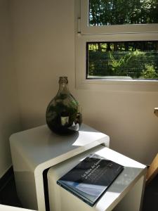 a vase sitting on top of a table with a book at Le Temps d'une Escale à St Wary in Saint-Valery-sur-Somme