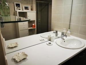 un bancone del bagno con lavandino e specchio di Le Temps d'une Escale à St Wary a Saint-Valéry-sur-Somme Altre 25 foto