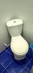 a white toilet in a bathroom with blue tiles at HOSTAL KENNDY in Valledupar