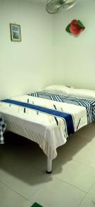 um quarto com uma cama com um cobertor azul e branco em HOSTAL KENNDY em Valledupar