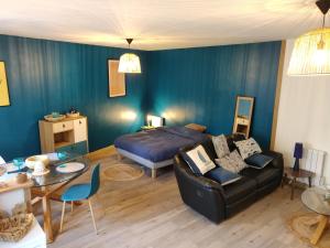- une chambre avec un canapé, un lit et une table dans l'établissement Maison calme "entre terre et mer" - proche gare - stationnement - jardin, à Saint-Brieuc