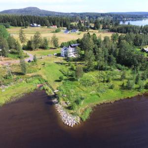Vista aèria de Nyrenoverat gårdshus på havstomt med hög standard