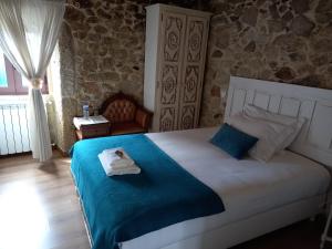 een slaapkamer met een bed met een handdoek erop bij Refúgio do Anjo - Alojamento Local in Lanhelas