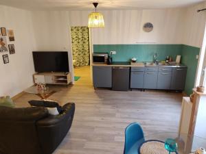 ein Wohnzimmer mit einem Sofa und einer Küche in der Unterkunft Maison calme "entre terre et mer" - proche gare - stationnement - jardin in Saint-Brieuc
