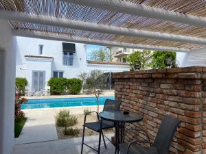 a patio with a table and chairs and a brick wall at Tagoo Vama Veche in Vama Veche +19 photos