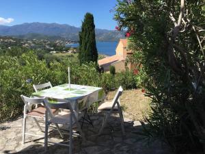 a table and chairs with a view of the ocean at Agriates in Patrimonio