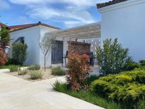 a pergola on a white house with plants at Tagoo Vama Veche in Vama Veche