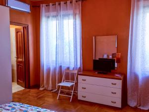 Un dormitorio con un tocador con TV. en La Finestra su Spello en Spello