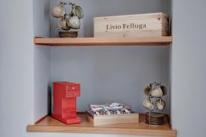 uma prateleira com panelas e frigideiras e uma caixa vermelha em Taste of Trieste Center em Trieste