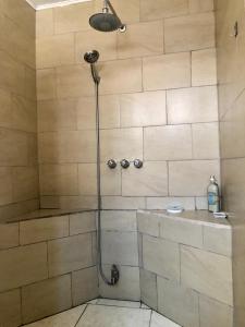 a shower with a shower head in a bathroom at Room near Airport/ Cerca del Aeropuerto in Santiago Este
