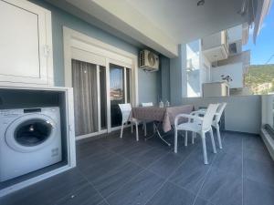 a living room with a washing machine and a table and chairs at Nastazia in Nea Peramos