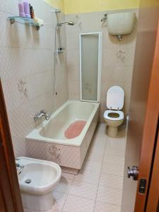 a bathroom with a toilet and a tub and a sink at La Finestra su Spello in Spello