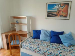 - une chambre avec un lit doté d'oreillers bleus et d'une chaise dans l'établissement Casa Riva Levante, à Gallipoli