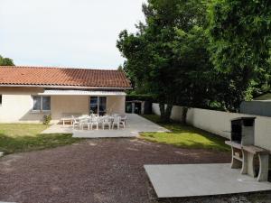 ein Haus mit einem Tisch und Stühlen im Hof in der Unterkunft Maison Royan 3 chambres avec salle d'eau, piscine in Royan