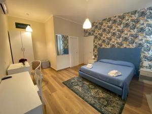 niewielka sypialnia z niebieskim łóżkiem i stołem w obiekcie Masseria Nobile Relais w mieście Fisciano