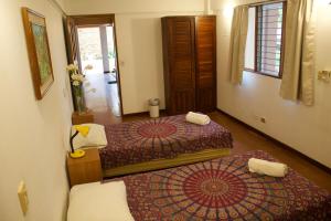 Habitación de hotel con 2 camas y espejo en Hostel Tajalín, en Montezuma