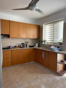 een keuken met houten kasten en een plafondventilator bij 2-bedroom Villa with private pool in Anarita Paphos in Anarita