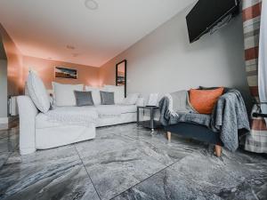 a living room with two white couches and two chairs at Waterfall Caves in Limavady