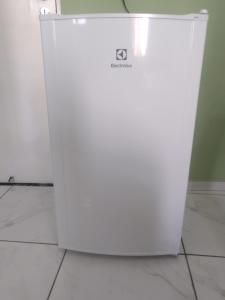 a white refrigerator sitting on a tile floor at Pousada Duende Feliz in São Thomé das Letras