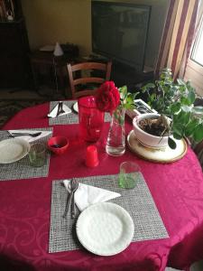 b&b bellavista في سافونا: طاولة مع قطعة قماش وردية مع الأطباق والزهور