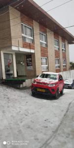 a red car parked in front of a building at Hotel Valley Vista in Mussoorie