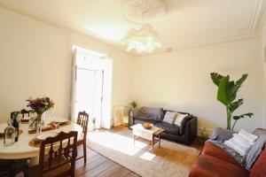 un soggiorno con un tavolo e un divano di Chalet Santa Rita - STUNNING APT. NEXT TO THE SEA a Estoril Altre 31 foto